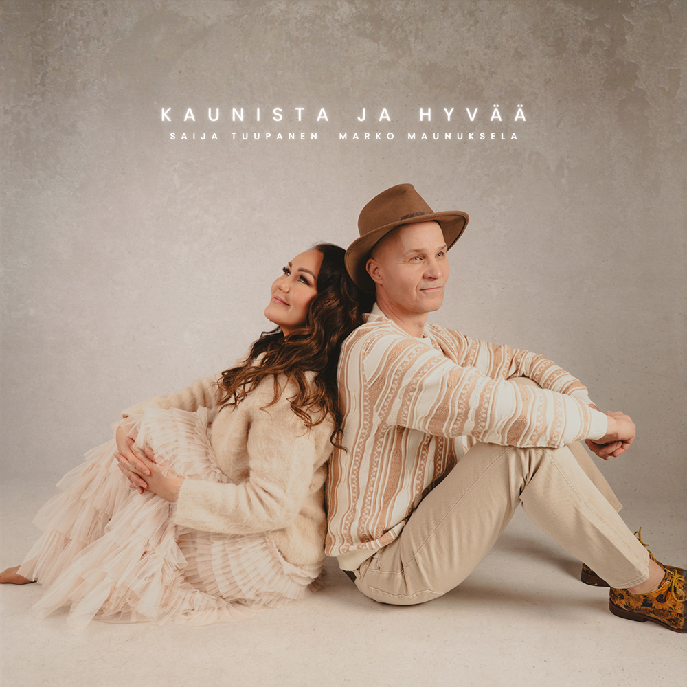 Saija_Tuupanen ja Marko_Maunuksela istuvat lattialla seläkkäin Kaunista ja hyvää -singlen kannessa.