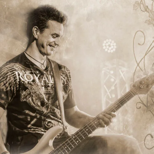 Janne Raappana with his guitar in a sepia-colored picture.