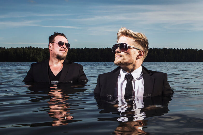 Käsityöläiset-bändin Mika Ikonen ja Anssi Häkkinen seisovat järvessä.