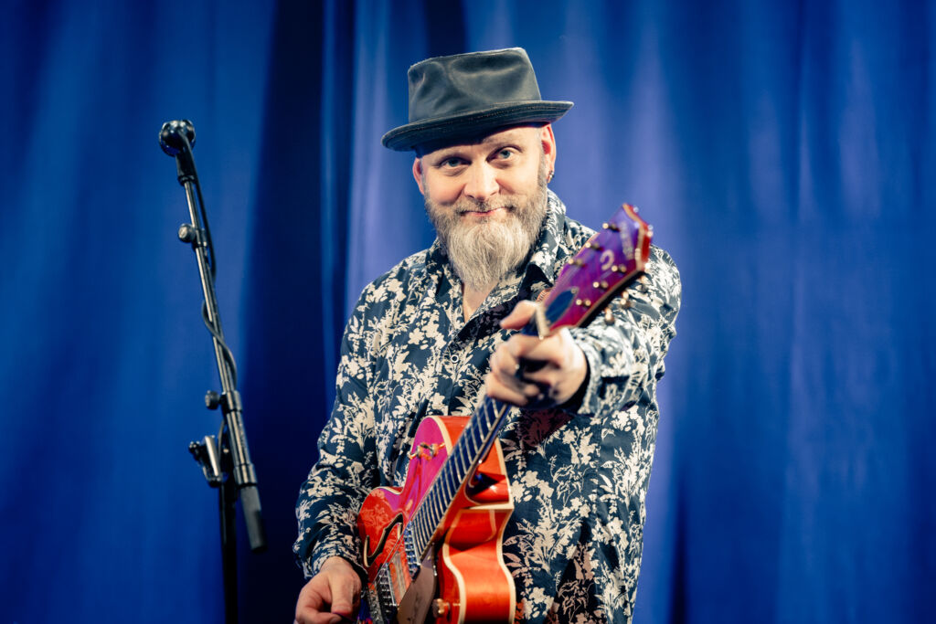 Peltone, eli MIka Peltonen kitaransa kanssa keikalla.