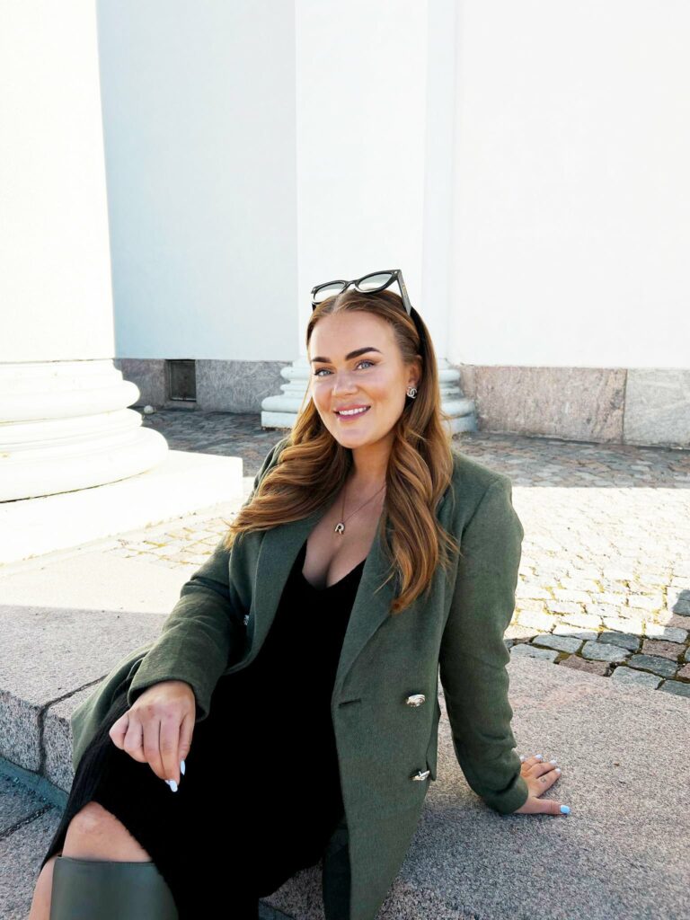 Juontaja Rosanna Kulju istuu ulkona.